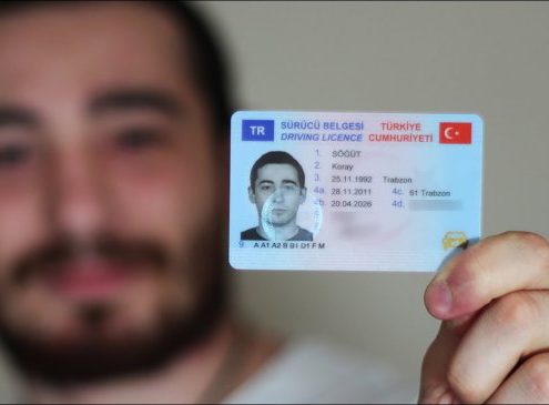 Yeni sürücü belgesini gösteren aday